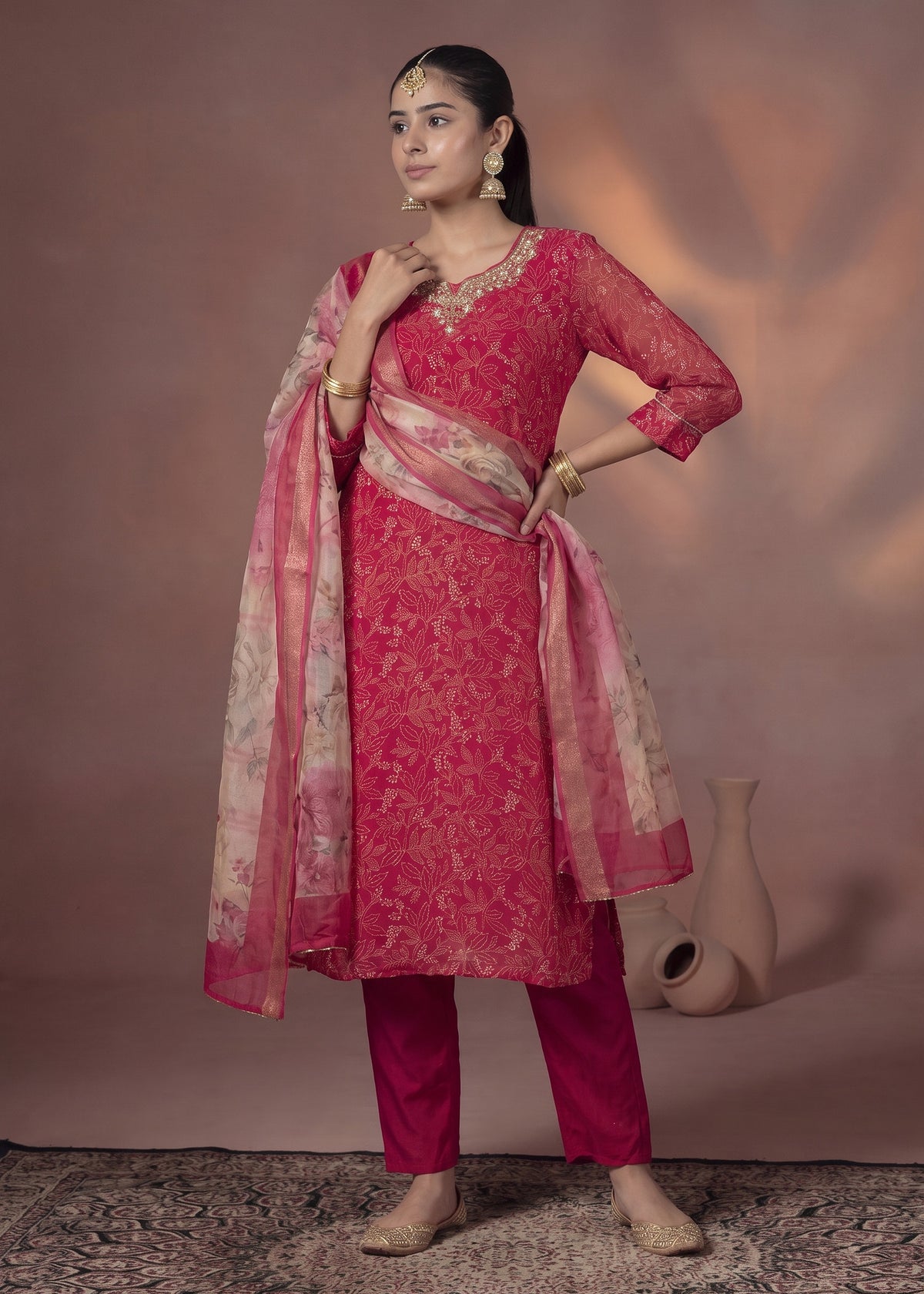 Deep pink kurta set with gold accents and floral dupatta – front view